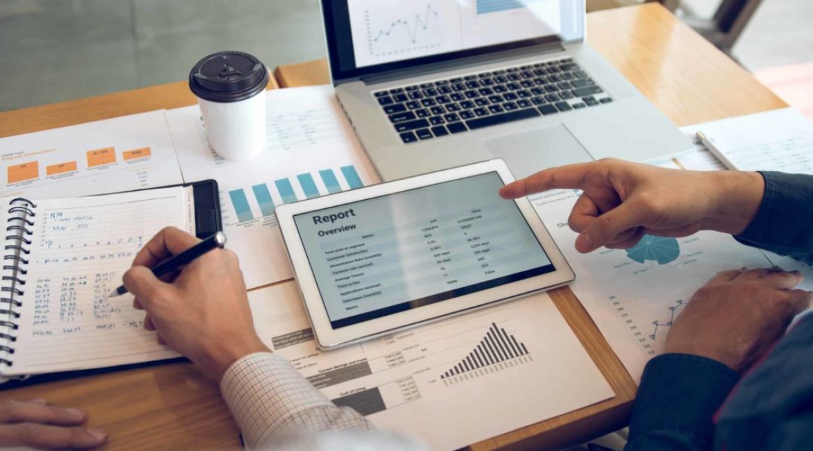 Business partnership coworkers using a tablet to analysis graph company financial budget report and cost work progress and planning for future in office room.